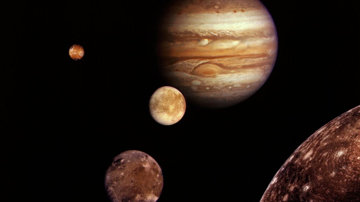 Jupiter and its four planet-size moons, called the Galilean satellites, were photographed in early March 1979 by Voyager 1 and assembled into this collage. They are not to scale but are in their relative positions. Startling new discoveries on the Galilean moons and the planet Jupiter made by Voyager l factored into a new mission design for Voyager 2. Reddish Io (upper left) is nearest Jupiter; then Europa (center); Ganymede and Callisto (lower right). Nine other much smaller satellites circle Jupiter, one inside Io's orbit and the other millions of miles from the planet. Not visible is Jupiter's faint ring of particles, seen for the first time by Voyager 1. The Voyager Project is managed for NASA's Office of Space Science by Jet Propulsion Laboratory, California Institute of Technology.