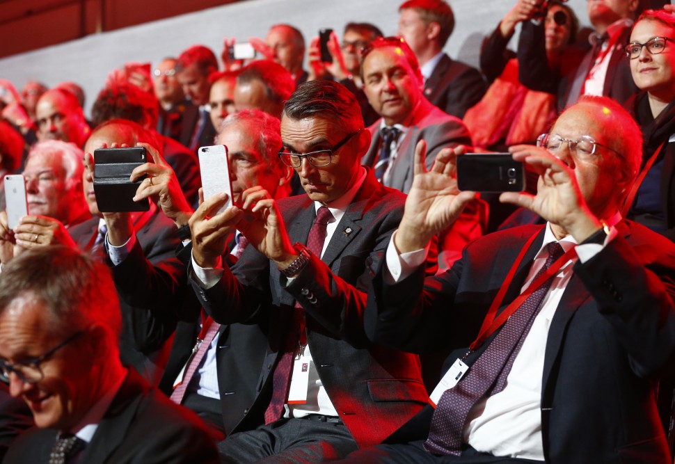 Guests use their mobile devices during the opening ceremony of the NEAT Gotthard Base Tunnel,  near the town of Erstfeld, Switzerland, Wednesday, June 1, 2016. The construction of the 57 kilometer long tunnel began in 1999, the breakthrough was in 2010. After the official opening on June 1, the commercial operation will start in  December 2016. (Ruben Sprich/Pool Photo vi AP)