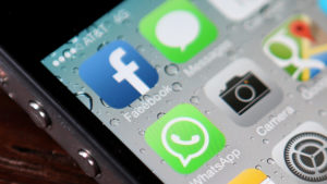 Tela do iOS mostrando o ícone do WhatsApp ao lado de outros três (Facebook, Mensagens e Câmera)