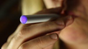 Imagem aproximada de uma pessoa fumando cigarro eletrônico