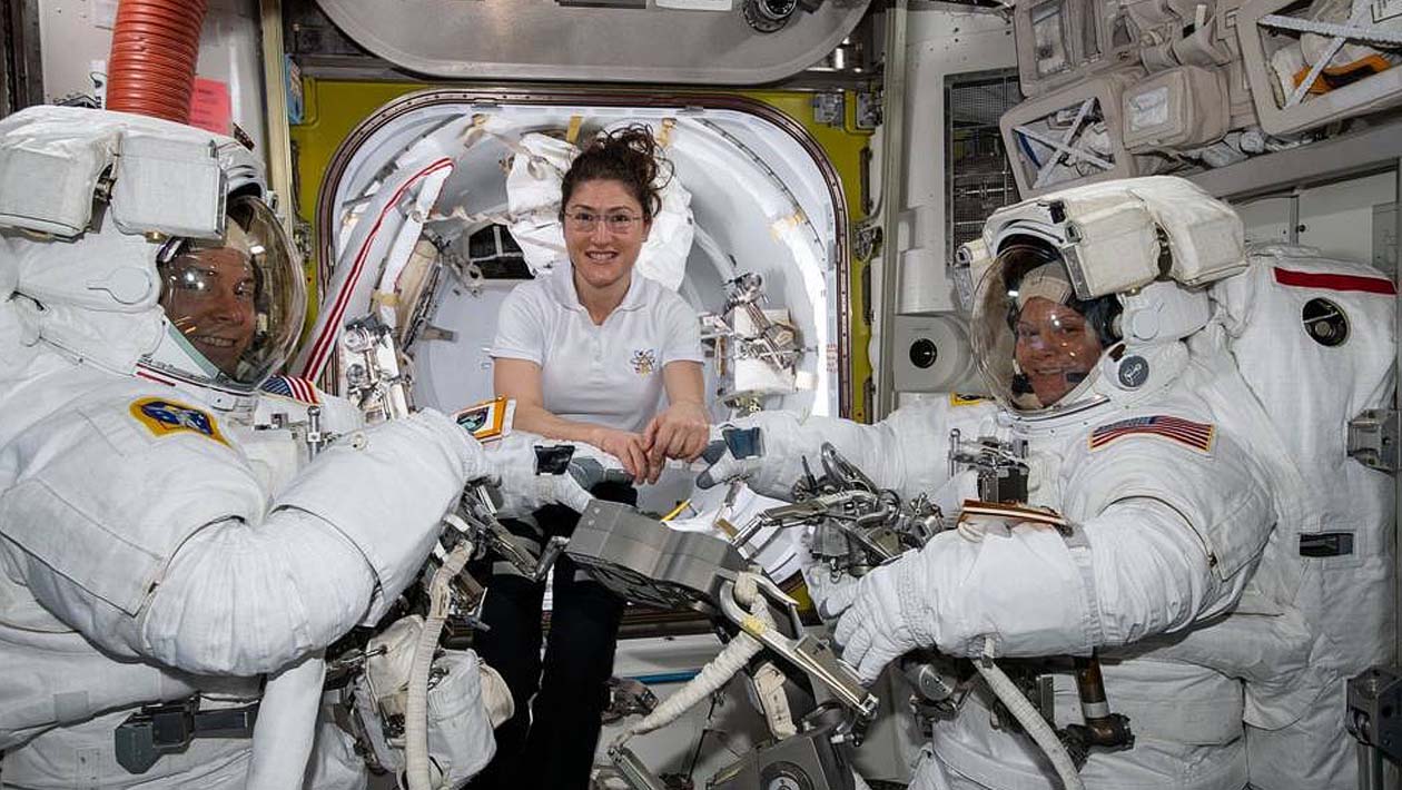Astronauta Christina Koch (centro) ajuda os colegas Nick Hague (esquerda) e Anne McClain na Estação Espacial Internacional