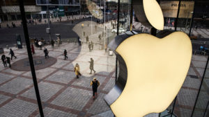 Logo da Apple visto de dentro de uma fachada de vidro.