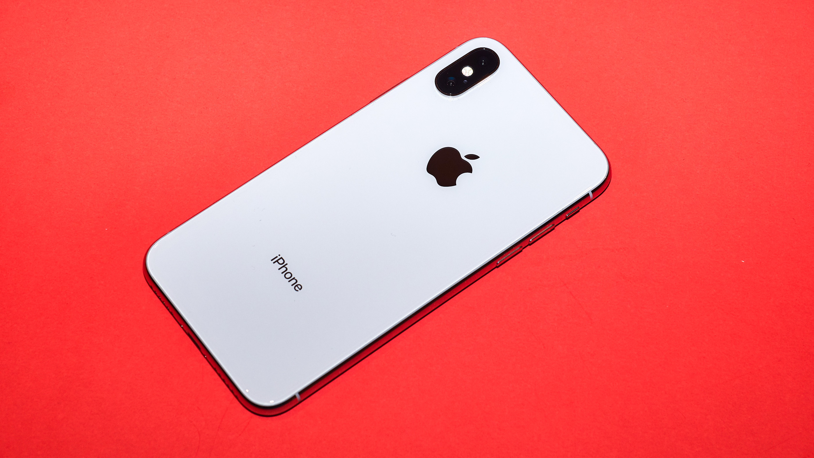 iPhone XS em um fundo vermelho