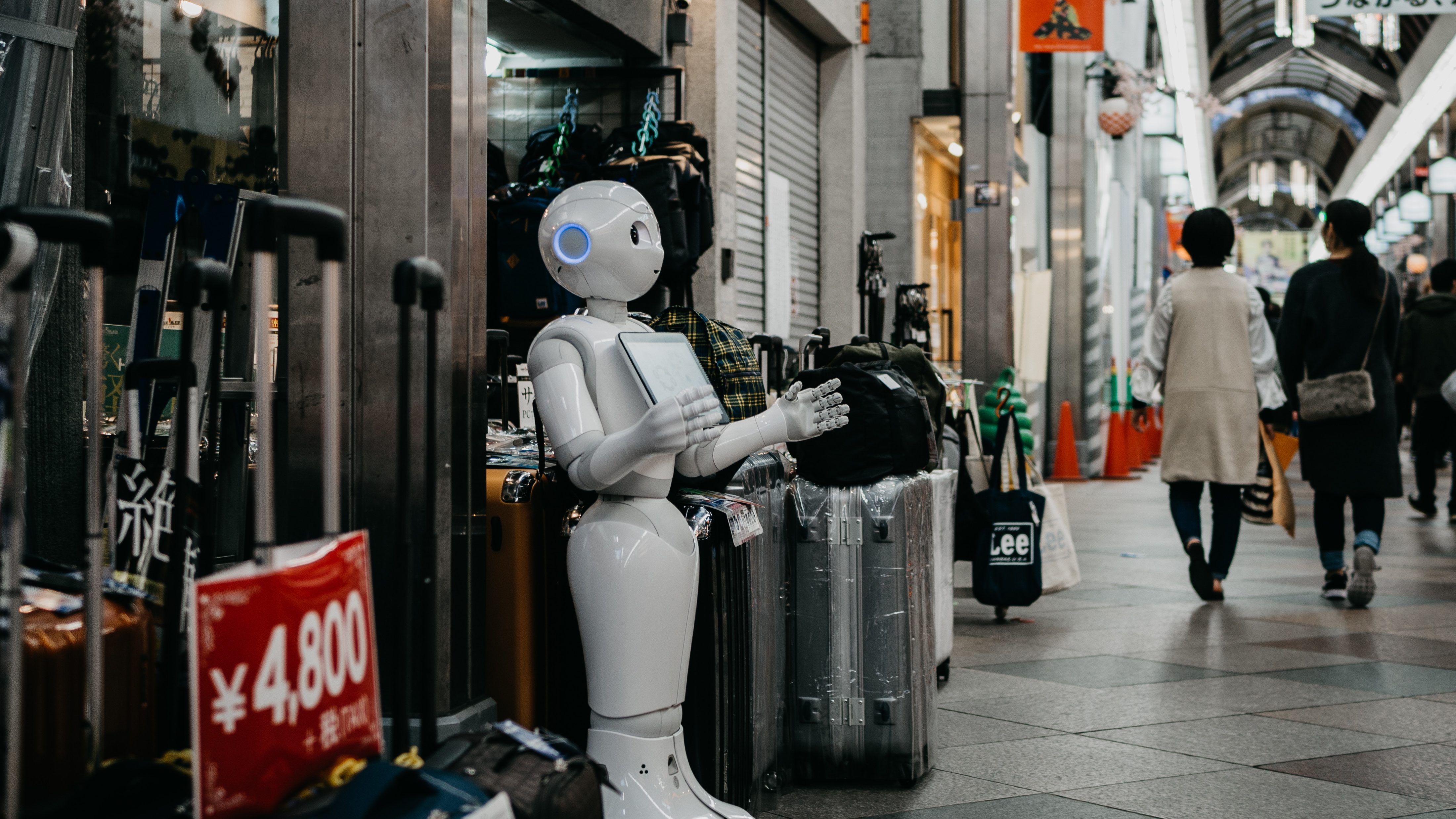 Robô em frente a uma loja ao lado de malas