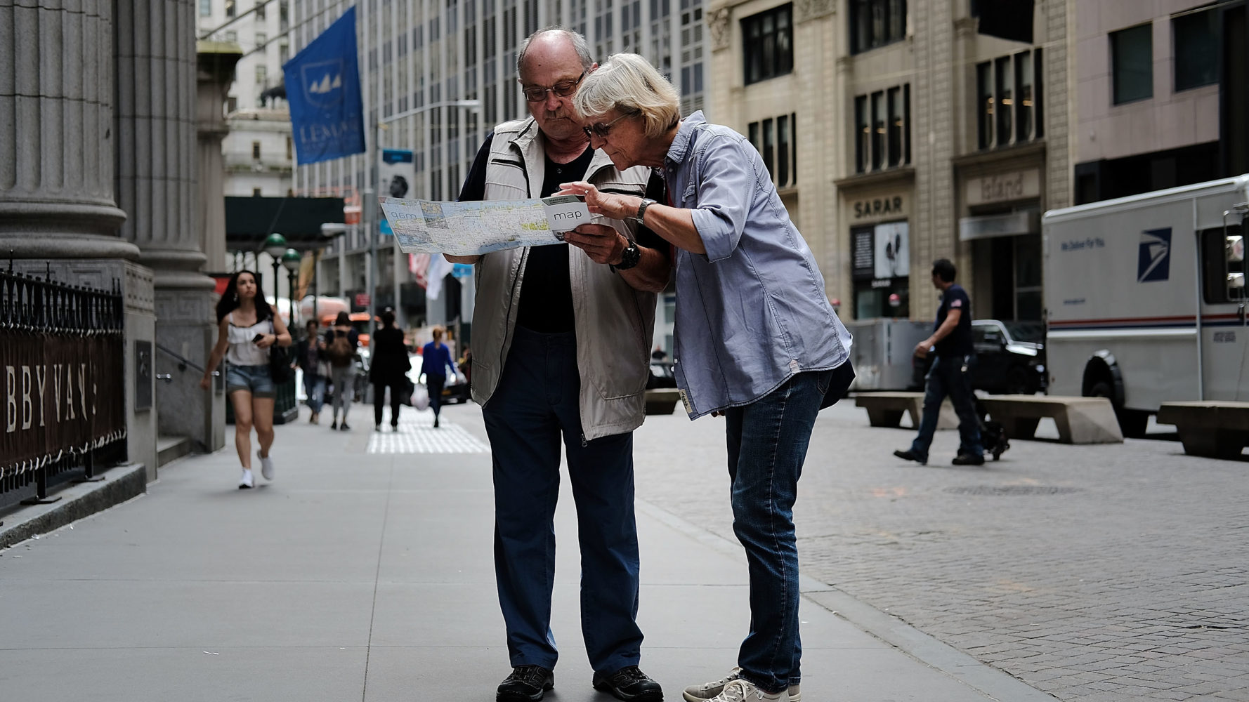 Turistas vendo mapa em uma calçada