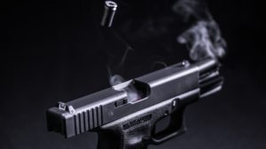 Pistola de cor preta disparando uma bala