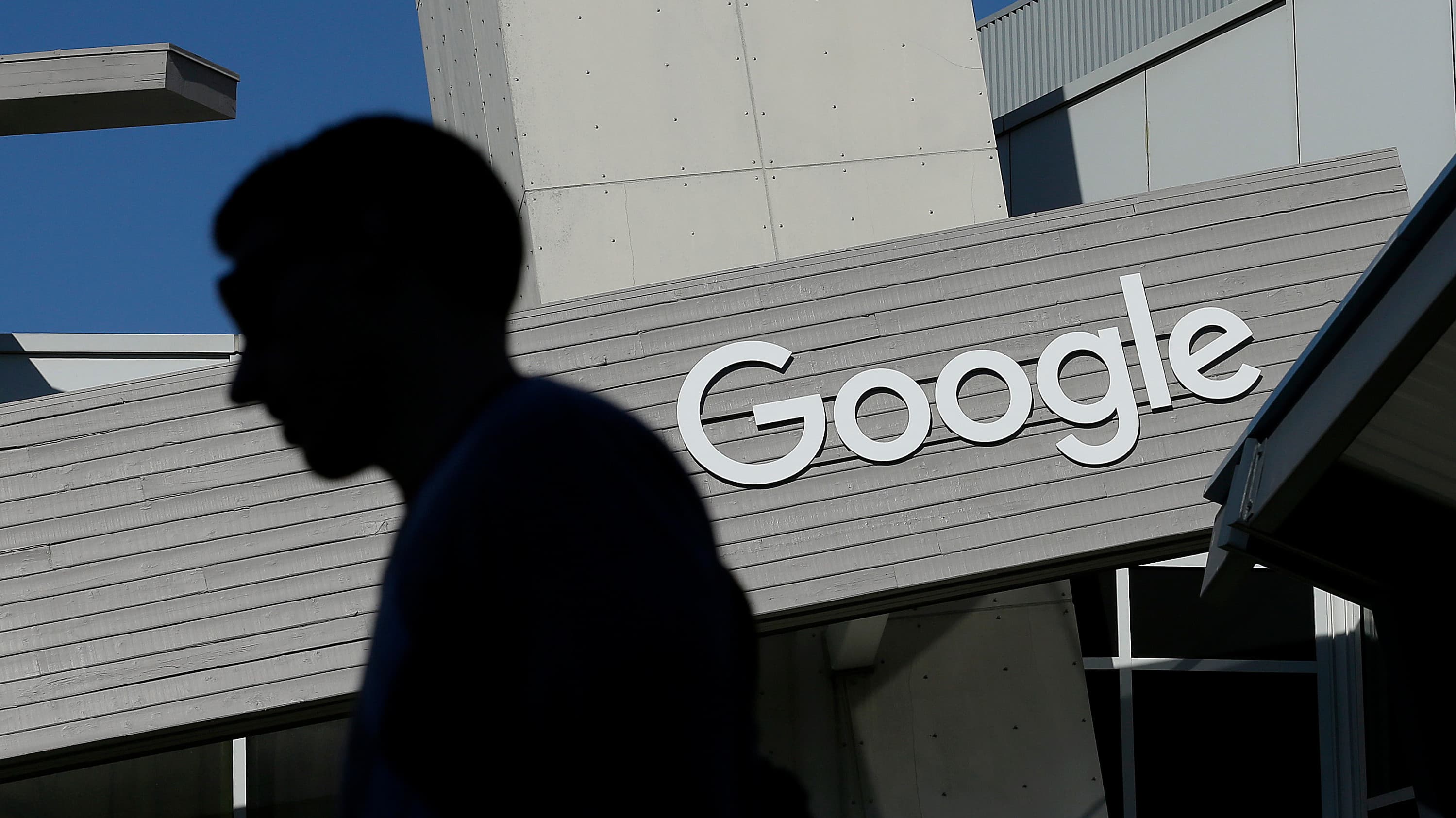 Homem passa em frente à logotipo do Google na sede da empresa na Califórnia, EUA