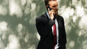 Homem vestido de terno faz ligação pelo celular