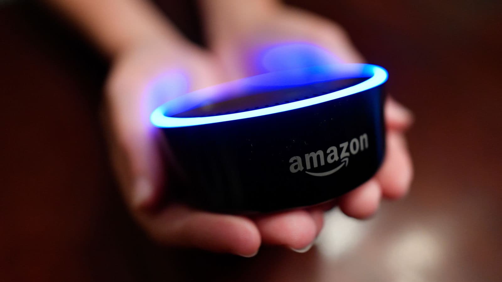 Pessoa segura um Amazon Echo, alto-falante com assistente Alexa, da Amazon