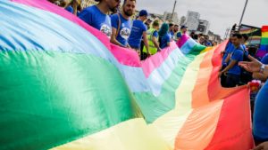 Pessoas seguram bandeira do orgulho gay. Crédito: Getty Images