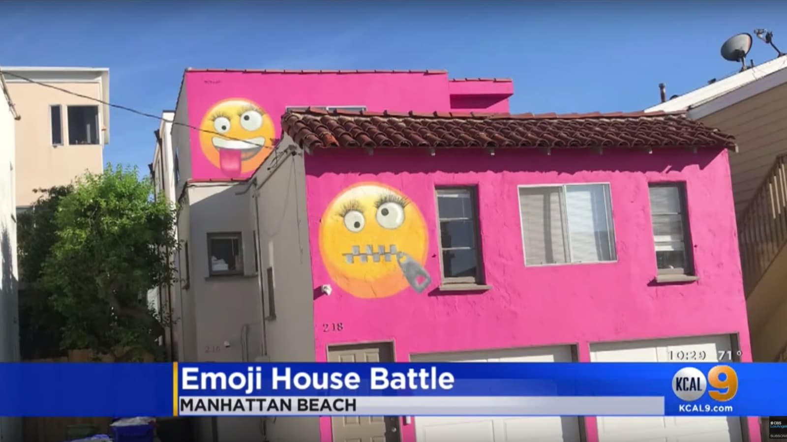 Casa com a fachada pintada de rosa e dois emojis desenhados