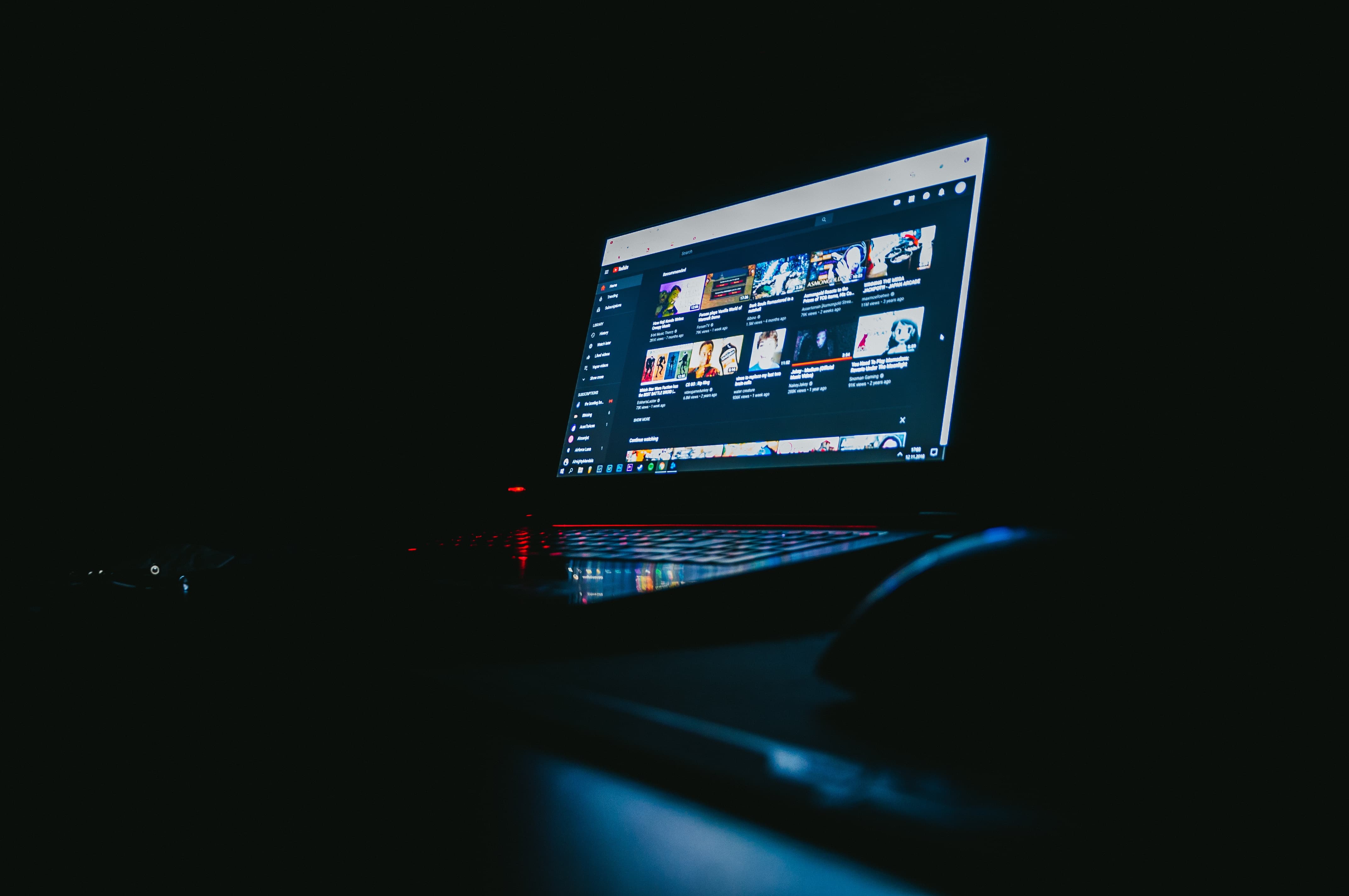 Laptop com YouTube na tela em uma sala escura