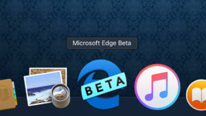 Imagem do ícone do Microsoft Edge (um e minúsculo azul) com uma faixa escrito "beta" por cima. O ícone está na dock do macOS.