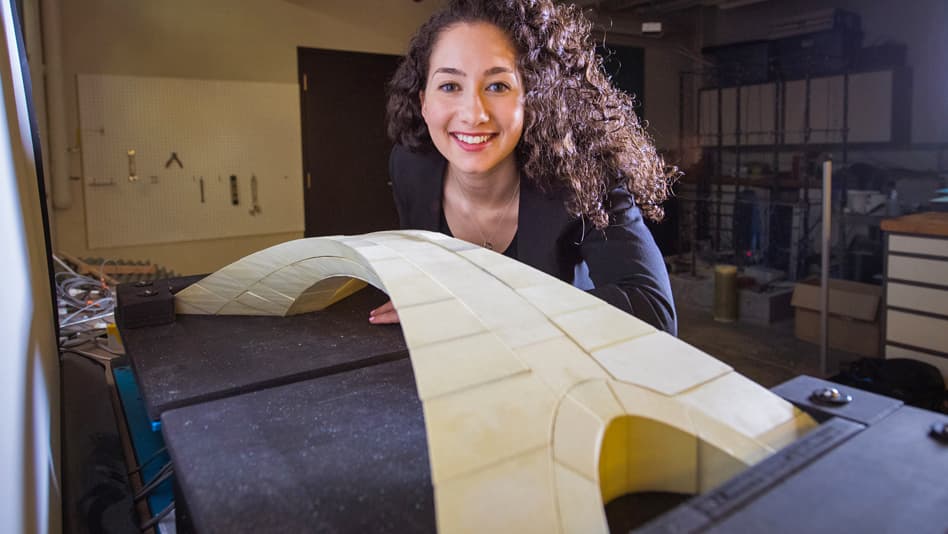Estudante posa ao lado de réplica feita em impressora 3D de desenho de ponte concebido por Leonardo Da Vinci
