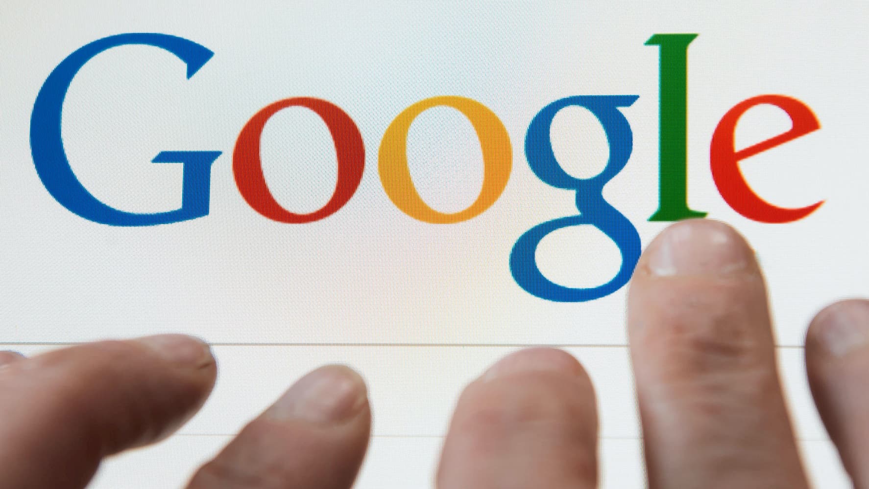 Dedos sobre o logotipo do Google em um computador