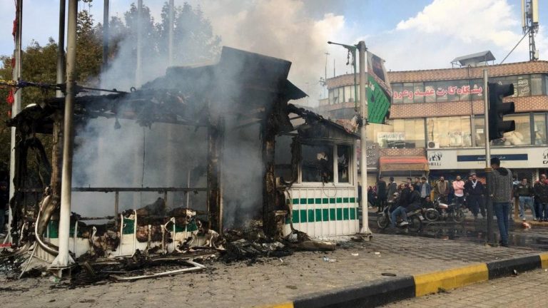 Iranianos se reúnem em torno de uma delegacia de polícia incendiada por manifestantes na cidade de Isfahan, em 17 de novembro de 2019