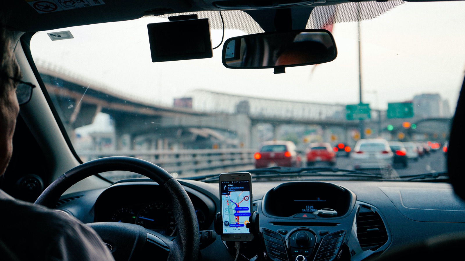Motorista de Uber com passageiro no carro e smartphone no painel