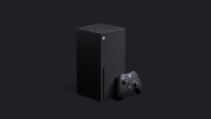 Imagem de um Xbox Series X: uma caixa preta retângular, com um joystick apoiado nela.