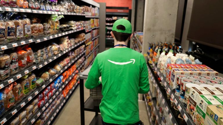 Pessoa com camiseta da Amazon passeia na loja Go Grocery