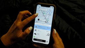 Mulher interagem com smartphone com app da Uber aberto