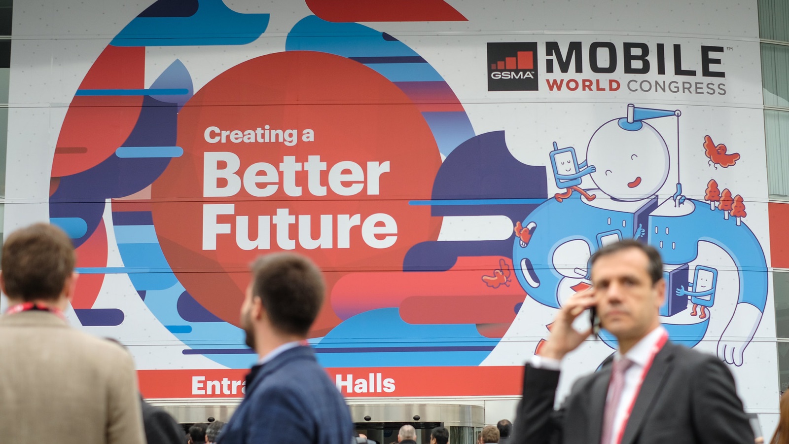 Pessoas em frente a painel do Mobile World Congress 2018
