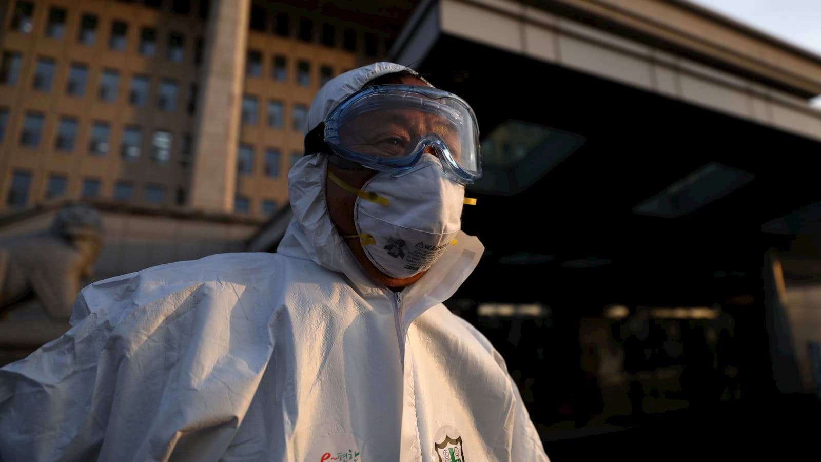 Trabalhador de saúde na Coreia do Sul se prepara para desinfetar o edifício da Assembleia Nacional em Seul