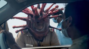 Policial Rajesh Babu vestindo um capacete com o formato do coronavírus, enquanto fala com um motorista em Chennai em 28 de março. Crédito: Getty Images