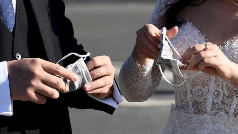 Casal colocando máscara de proteção facial