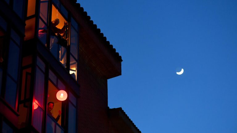 Pessoas confinadas em suas casas aplaudem de suas janelas os trabalhadores de saúde que estão lidando com o surto de COVID-19, em Madri, em 28 de março. Crédito: Getty Images