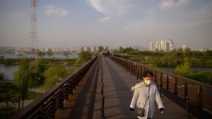 Uma mulher caminha ao longo de uma ponte perto do distrito de Yeouido, em Seul, Coréia do Sul.
