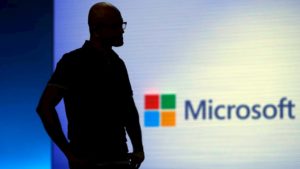 Silhueta de Satya Nadella com logo da Microsoft ao fundo