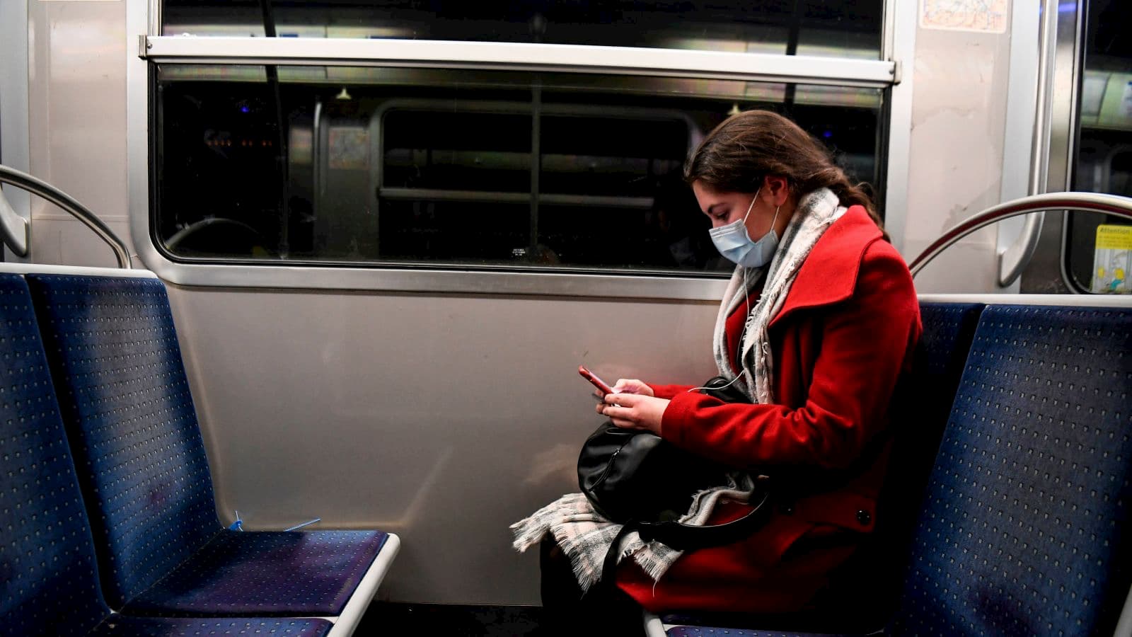 Mulher mexe no celular no metrô