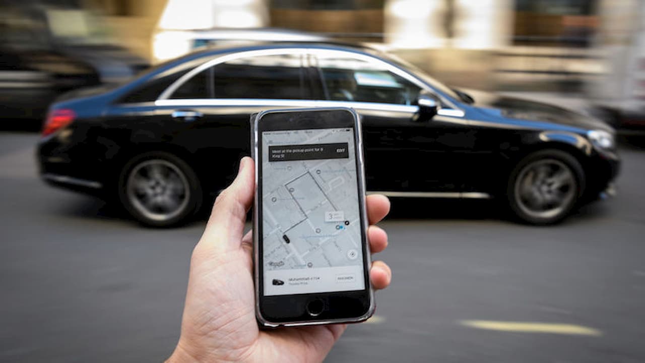 Pessoa segurando celular com app do Uber aberto