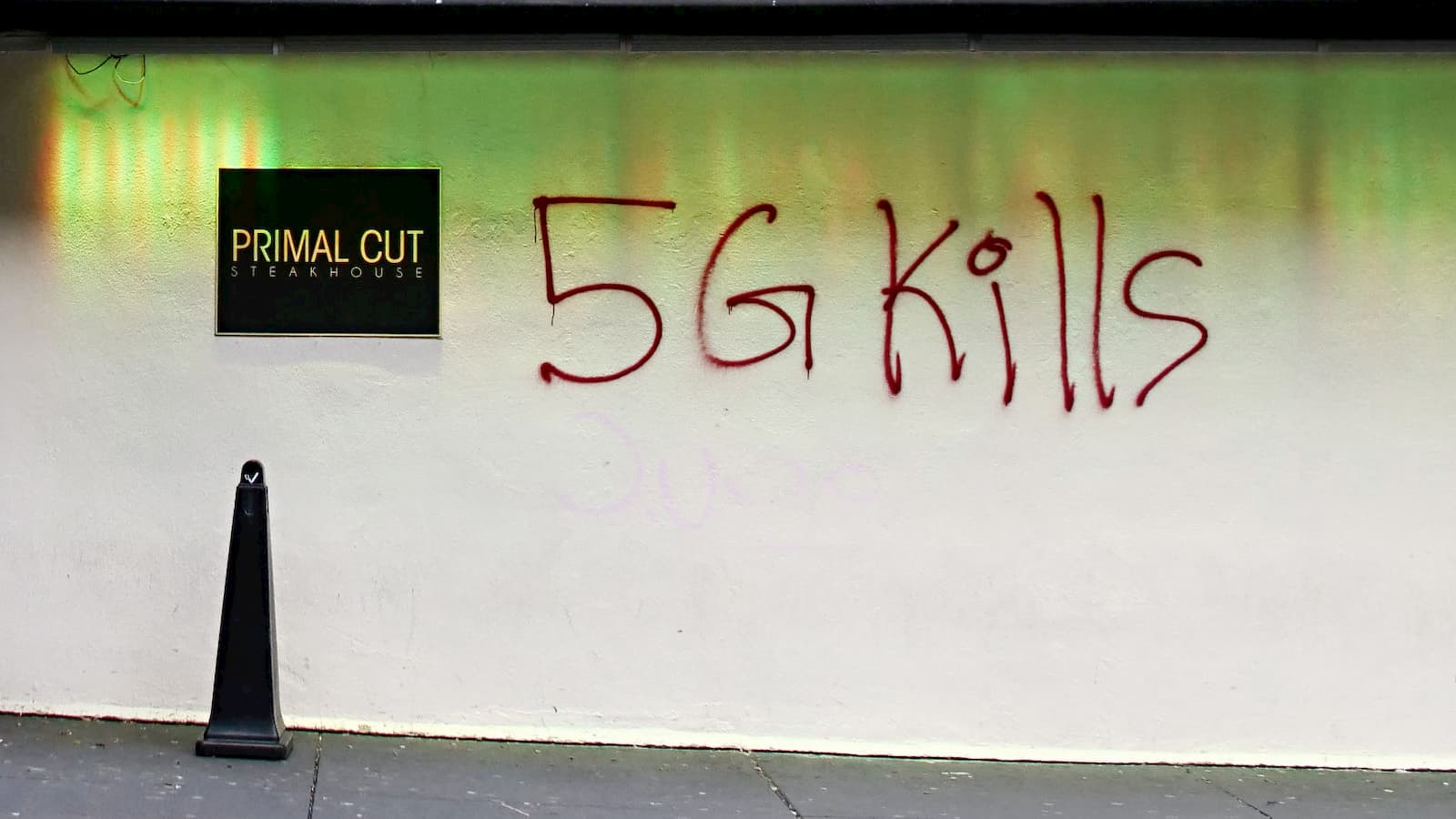 Muro pixado com a frase 5G mata, em inglês