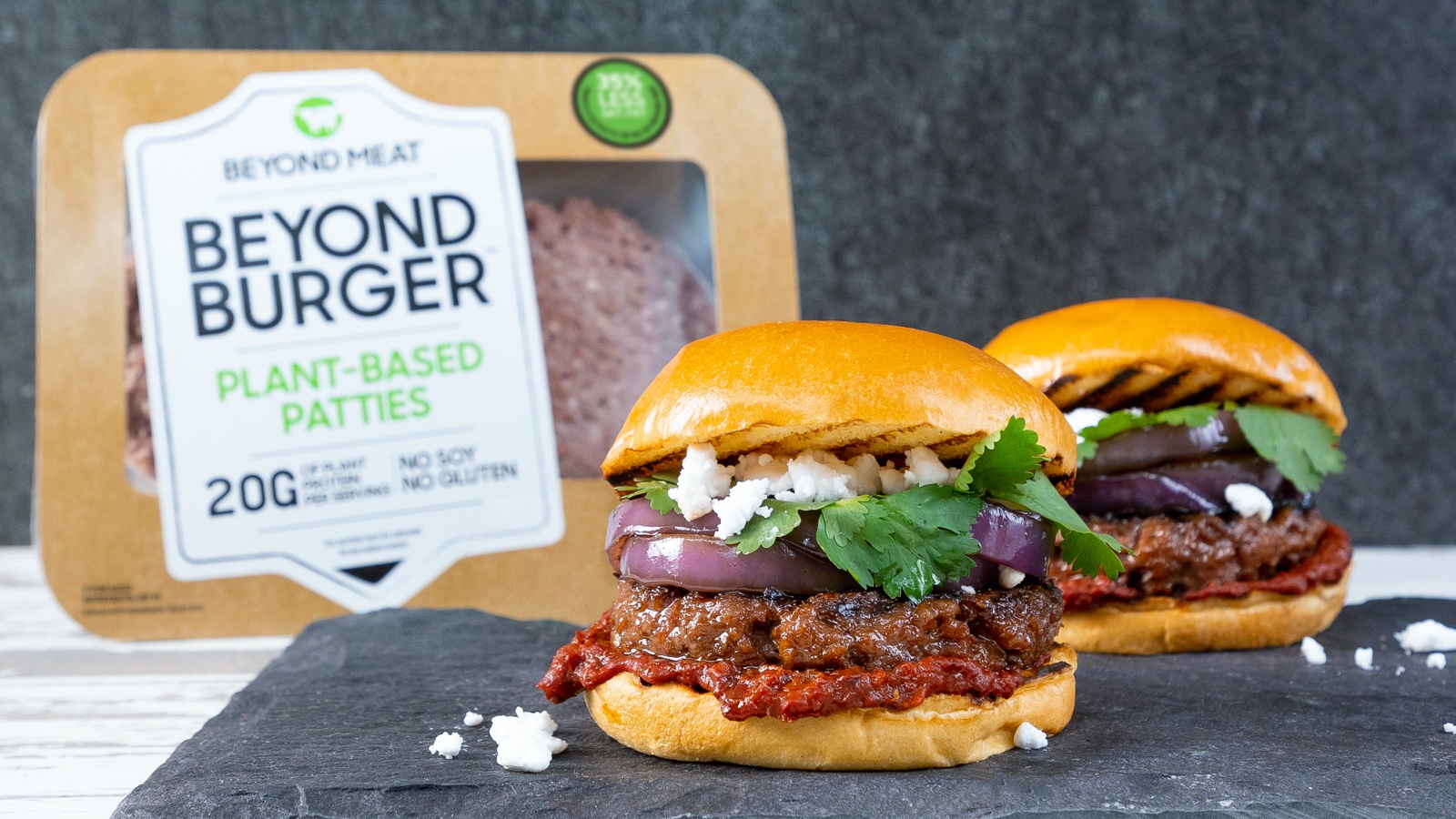 Dois hambúrgueres e uma embalagem com dois discos de hambúrguer vegano da Beyond Burger. Crédito: Beyond Burger