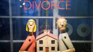 Bonecos ilustram cena de divórcio com casa separada ao meio