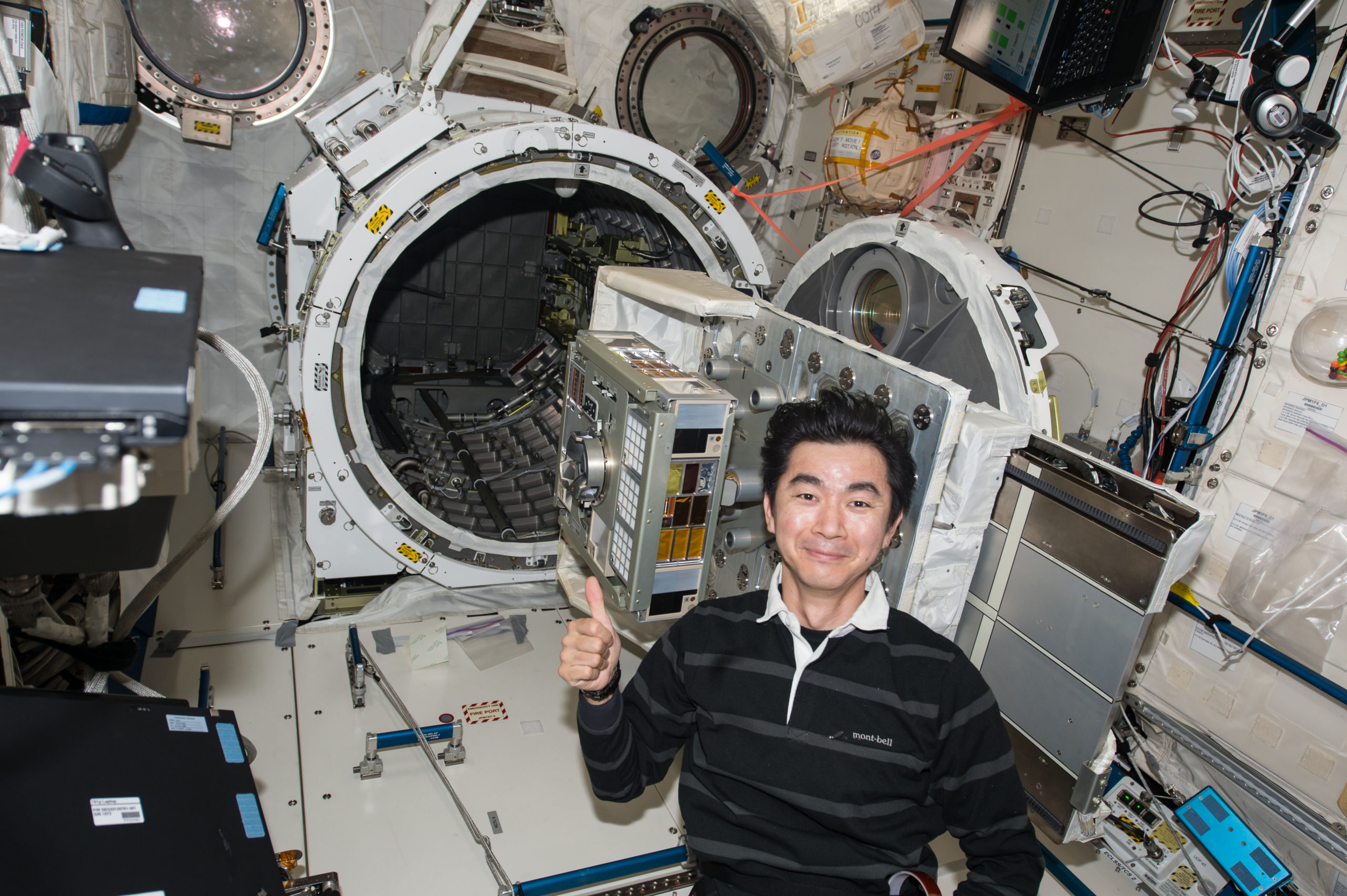 Astronauta japonês Kimiya Yui preparando o módulo de experimento para exposição. Crédito: JAXA/NASA