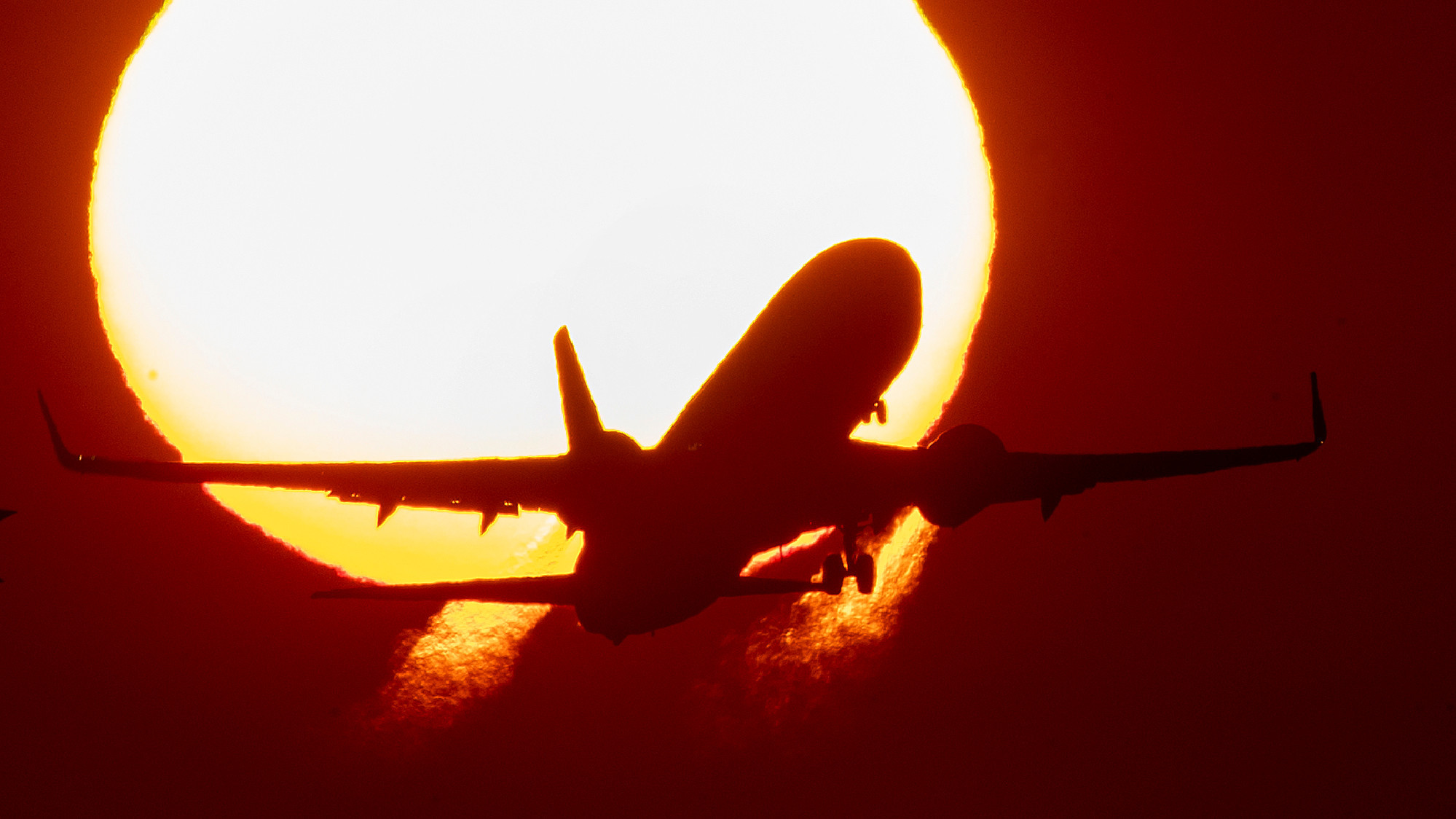 Avião voando com Sol radiante ao fundo. Crédito: AP