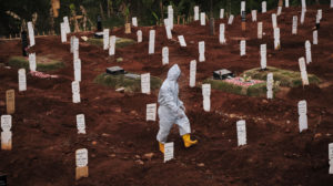 Funcionário de cemitério municipal caminha por área específica para suspeitos de morte por COVID-19 em Jacarta, na Indonésia. Crédito: Ed Wray/Getty Images