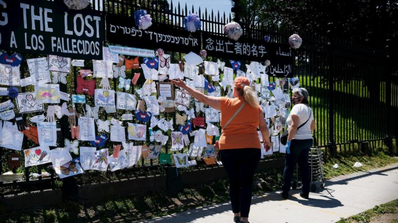 Mulher visita memorial para homenagear vítimas do coronavírus em frente ao cemitério Green-Wood nos EUA. Crédito: Spencer Platt/Getty Images
