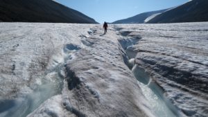 Alpinista anda sobre canais de água em geleira de Longyarbeen