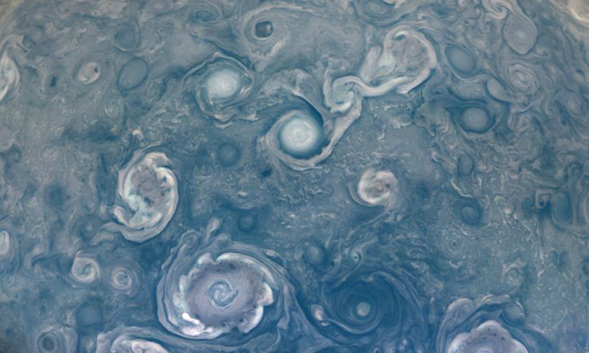Foto tirada pela sonda Juno, da NASA, mostra ciclones no polo norte do planeta Júpiter.