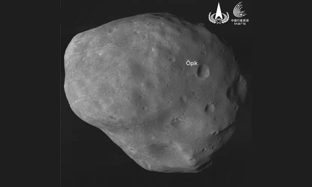 A foto mostra a lua Fobos, com detalhe que aponta para a cratera Öpik no canto direito do satélite.