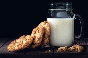 Tolerância à Lactose - A imagem mostra um copo de leite ao lado de biscoitos.