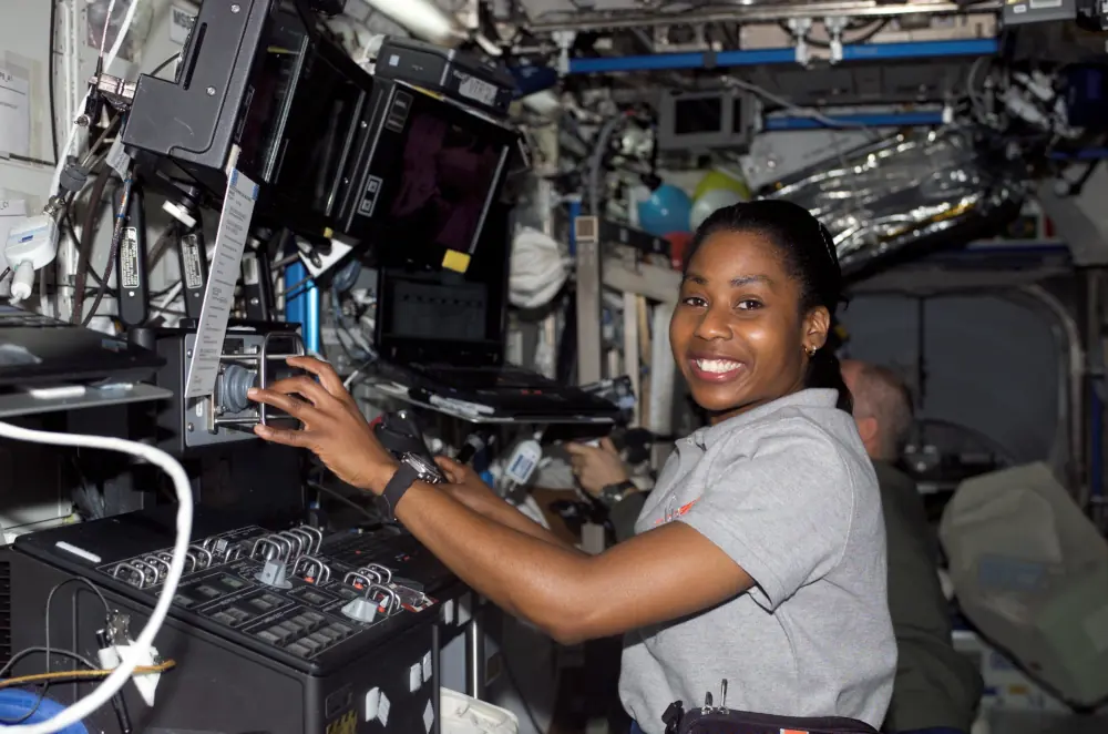 A astronauta Stephanie Wilson a bordo do módulo Destiny, da ISS, mexendo nos controles do braço robótico Canadarm2, da estação espacial.