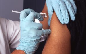 enfermeiro aplicando vacina no braço de uma pessoa