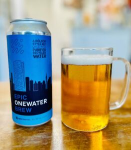fotografia de uma lata da epic onewater brew ao lado de uma caneca com a cerveja
