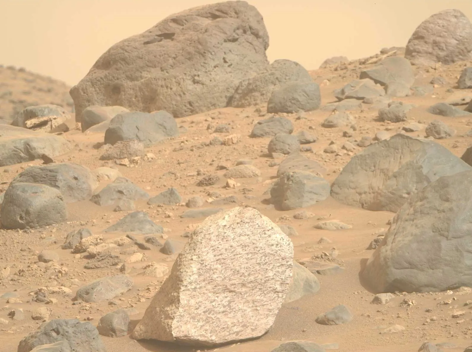 Foto mostrando rocha "pipoca" em cor natural pela câmera do rover, antes da edição.