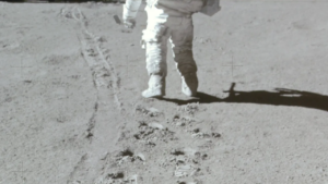 Astronauta Neil Armstrong na Lua com uma trilha de pegadas